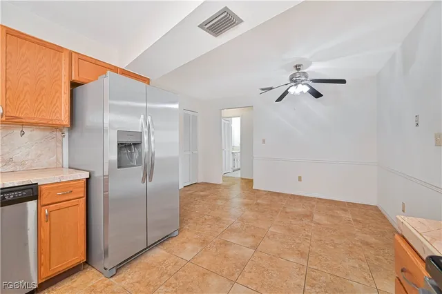 a kitchen with stainless steel appliances kitchen island a refrigerator sink and cabinets