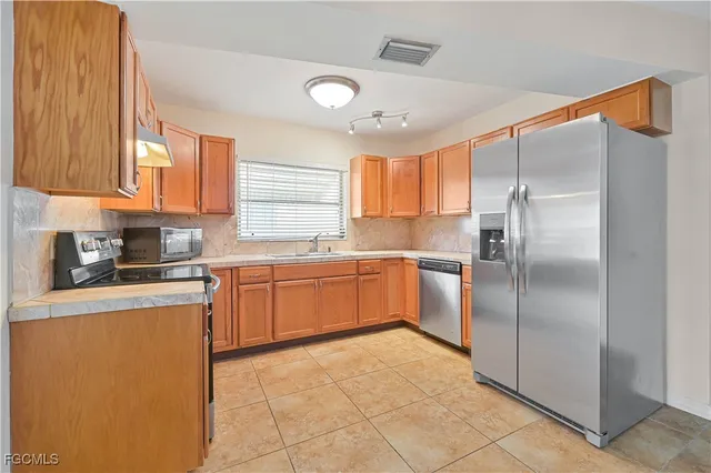 a kitchen with a refrigerator sink and cabinets