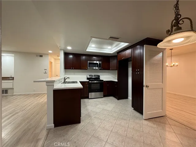 a kitchen with stainless steel appliances kitchen island granite countertop a refrigerator and a sink