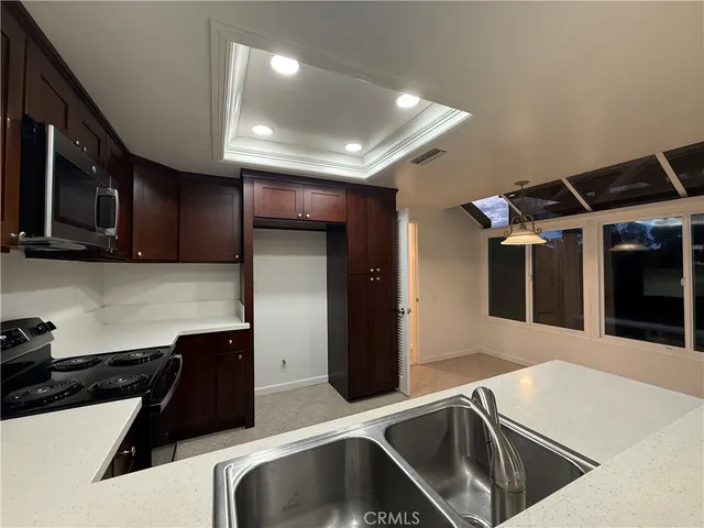 a kitchen with stainless steel appliances kitchen island granite countertop a sink and a stove