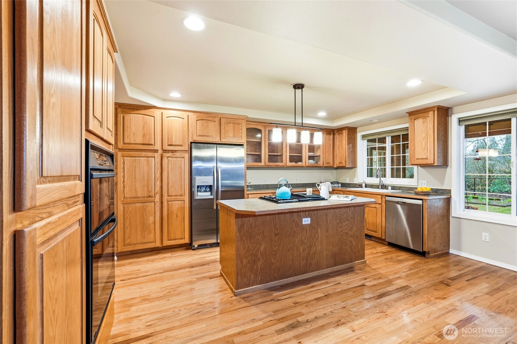 1026 McRae Road Northwest Arlington, WA 98223 - Photo 17 of 40 a kitchen with stainless steel appliances granite countertop a refrigerator a sink dishwasher a stove and a dining table with wooden floor