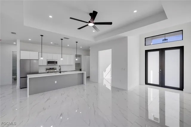 a large kitchen with stainless steel appliances kitchen island a refrigerator sink and cabinets