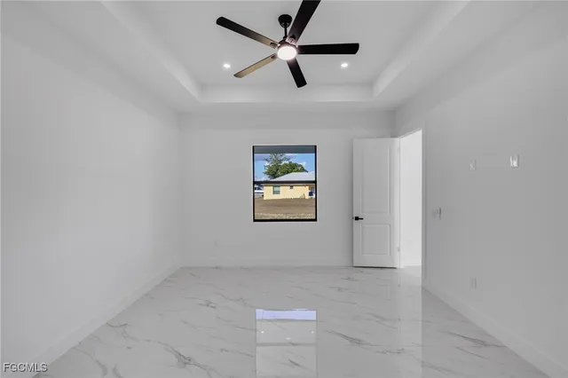 an empty room with windows and fan