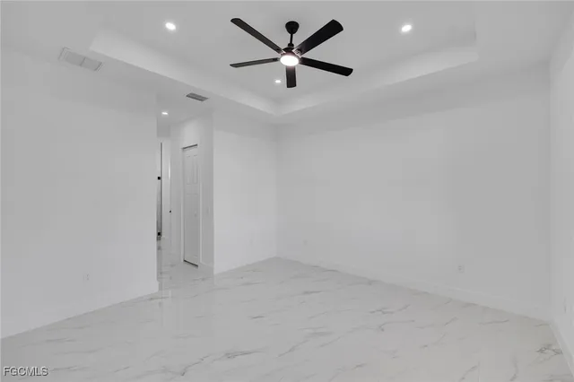 an empty room with a ceiling fan and a window