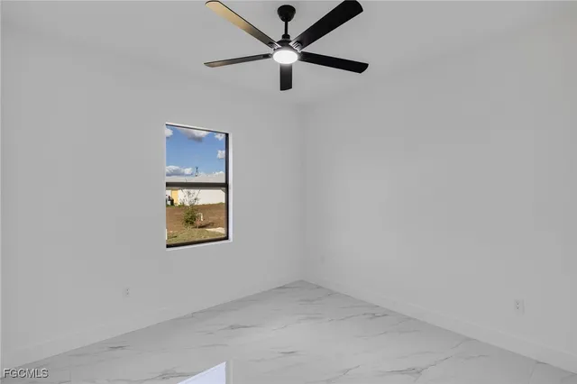 an empty room with a window and a ceiling fan