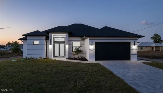 a front view of a house with a yard and garage