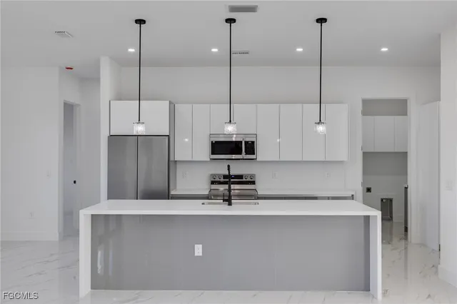 a kitchen with kitchen island a sink a center island a stove and a window