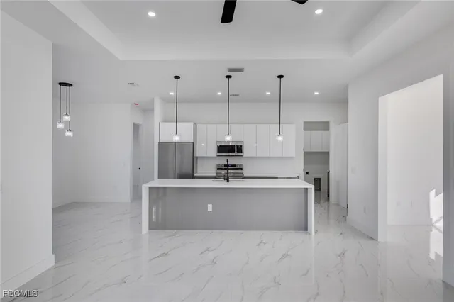 a view of kitchen with stainless steel appliances granite countertop a sink and a refrigerator