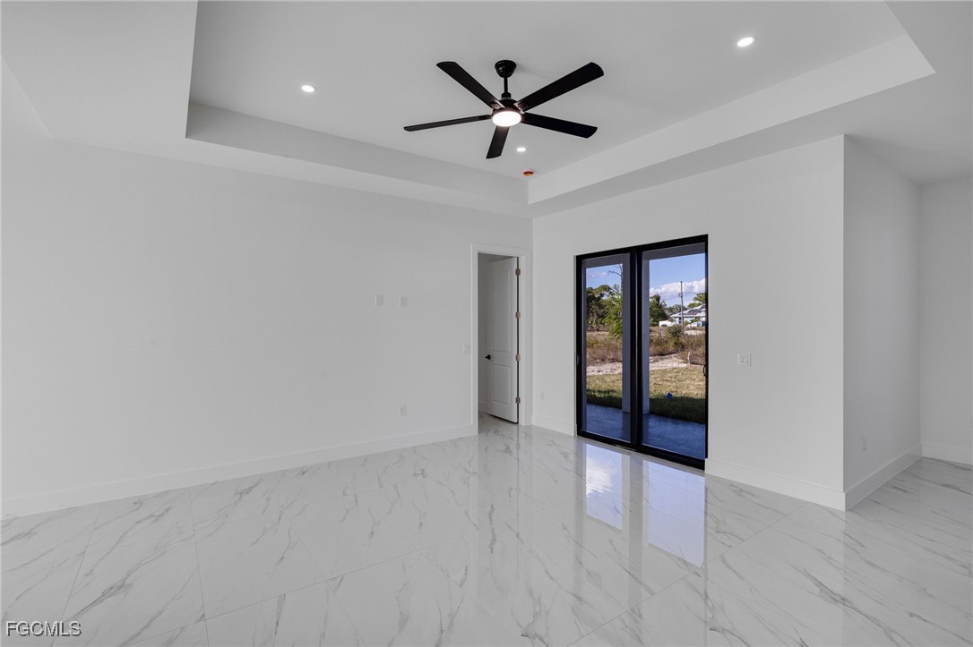 2506 36th Street Southwest Lehigh Acres, FL 33976 - Photo 10 of 25 wooden floor in an empty room with a ceiling fan