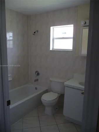 a white toilet sitting next to a bath tub