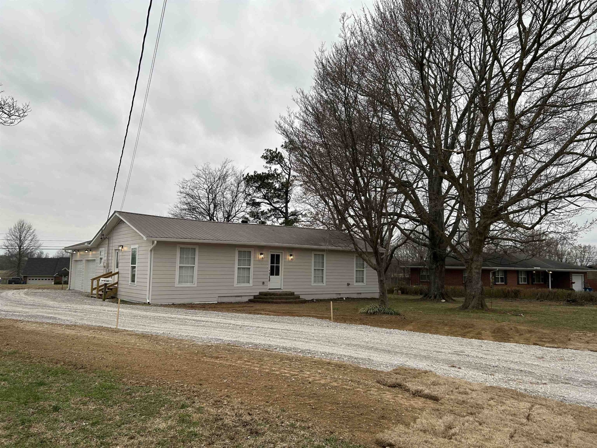 a front view of a house with a garden and trees