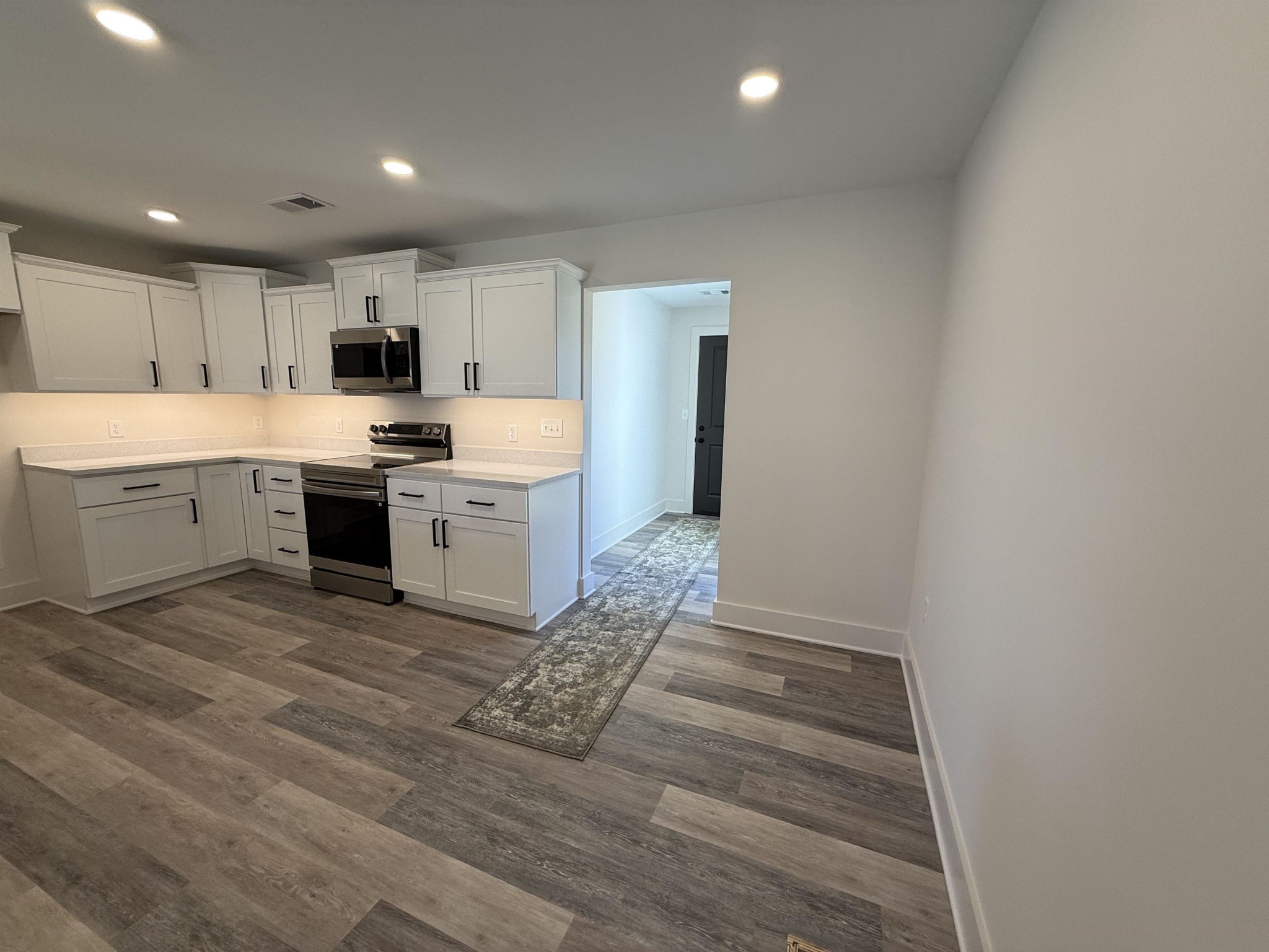 963 Highway 54 Covington, TN 38019 - Photo 11 of 26 a kitchen with kitchen island a sink a stove a refrigerator and white cabinets