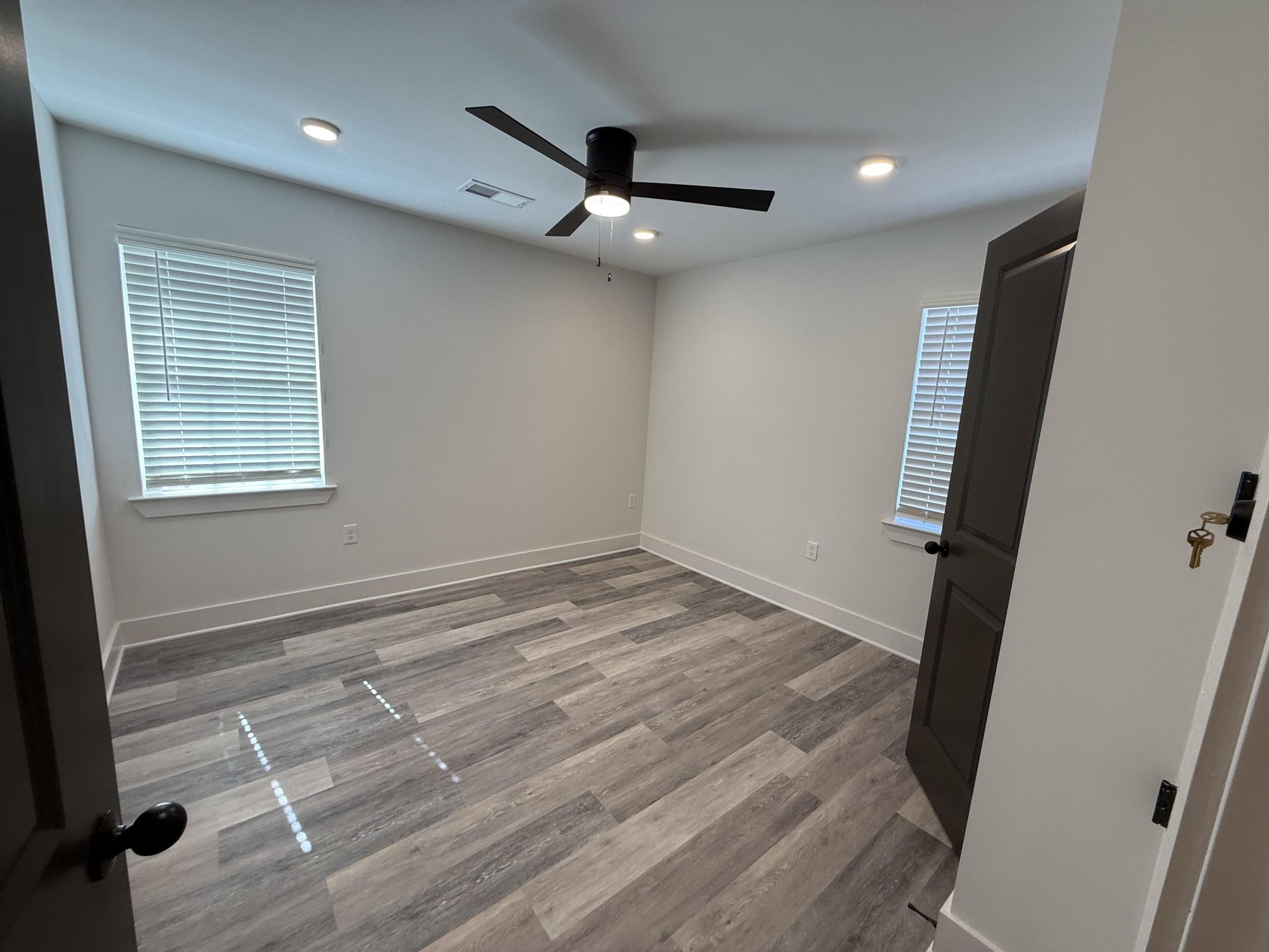 963 Highway 54 Covington, TN 38019 - Photo 21 of 26 an empty room with wooden floor and windows