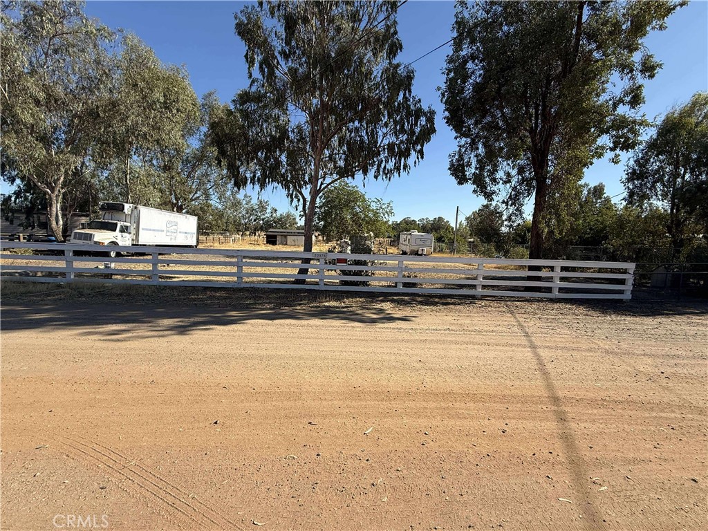 a view of a yard with wooden fence