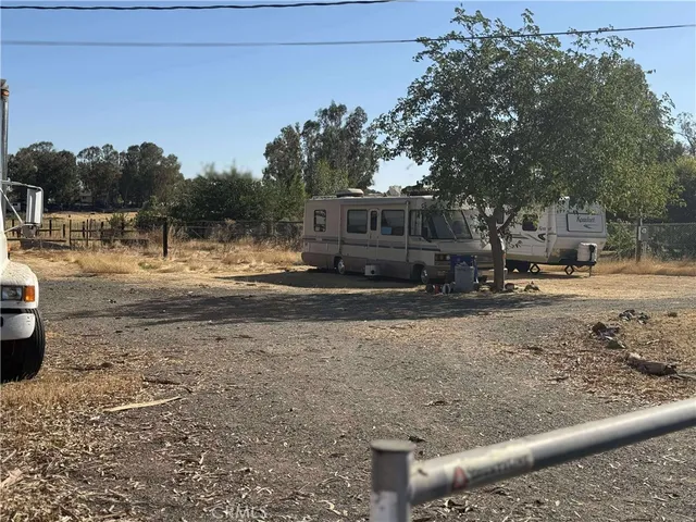 a view of dirt yard with a large tree