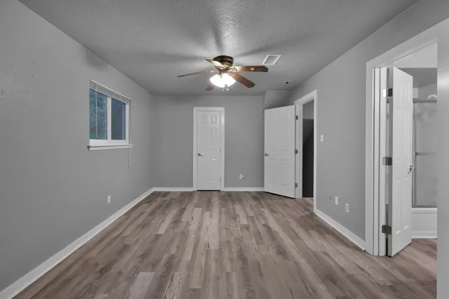 a view of empty room with wooden floor