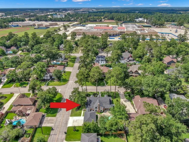 an aerial view of residential houses with outdoor space and trees