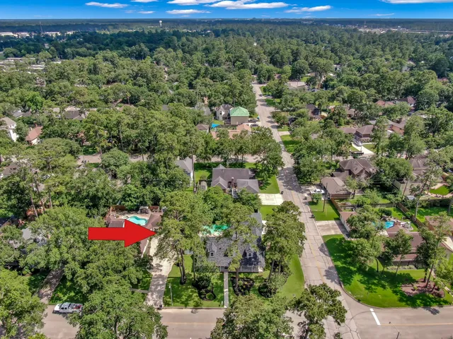 an aerial view of residential houses with outdoor space and trees