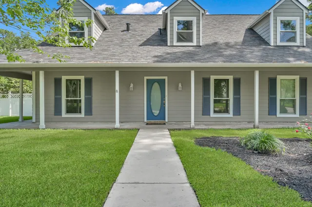 front view of a brick house with a yard