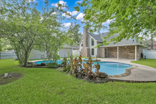 a view of a backyard with table and chairs and a large tree