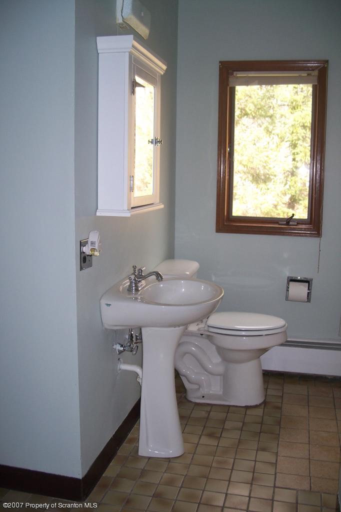 7432 Turnpike Road Montrose, PA 18801 - Photo 8 of 13 a bathroom with a sink toilet and mirror