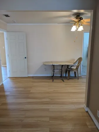 a view of a room with wooden floor and chandelier