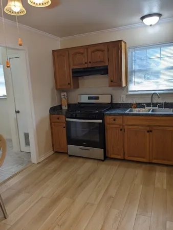 a kitchen with stainless steel appliances granite countertop a stove a sink and a microwave