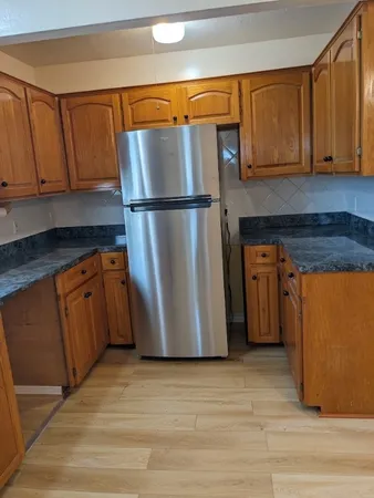 a kitchen with a refrigerator sink and cabinets