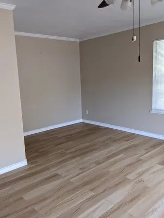 a view of an empty room with wooden floor