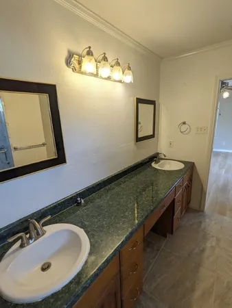 a bathroom with a granite countertop sink and a mirror