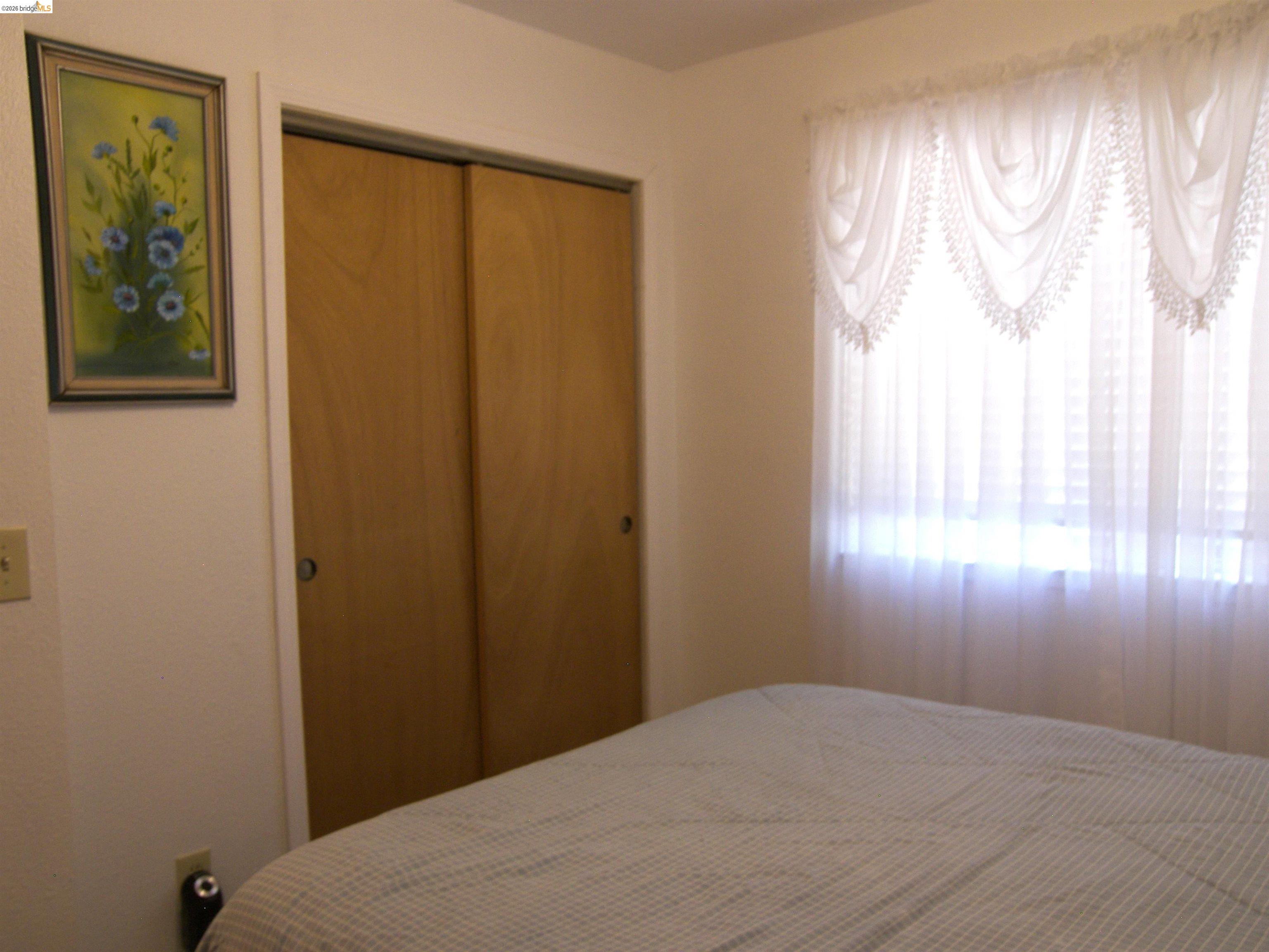 19215 Ferretti Road Groveland, CA 95321 - Photo 16 of 40 Bright bedroom with sheer curtsins & wood closet doors.