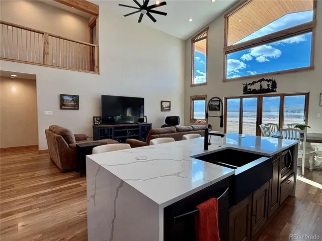 a kitchen with stainless steel appliances a table chairs in it and wooden floors
