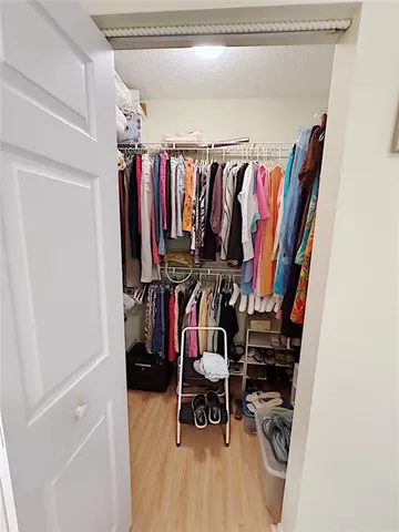 a view of walk in closet with clothes and shoes