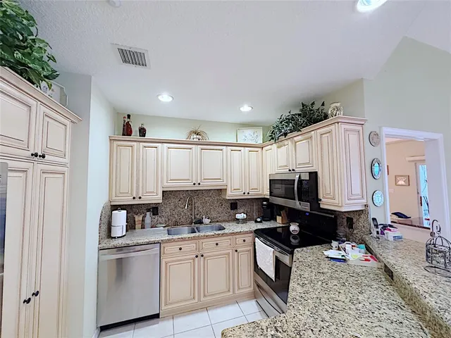 a kitchen with stainless steel appliances granite countertop a stove a sink and a refrigerator