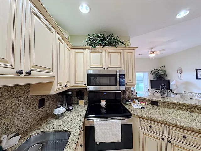 a kitchen with granite countertop a sink and a stove top oven