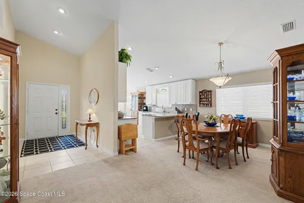 a living room with furniture a dining table and chairs with kitchen view