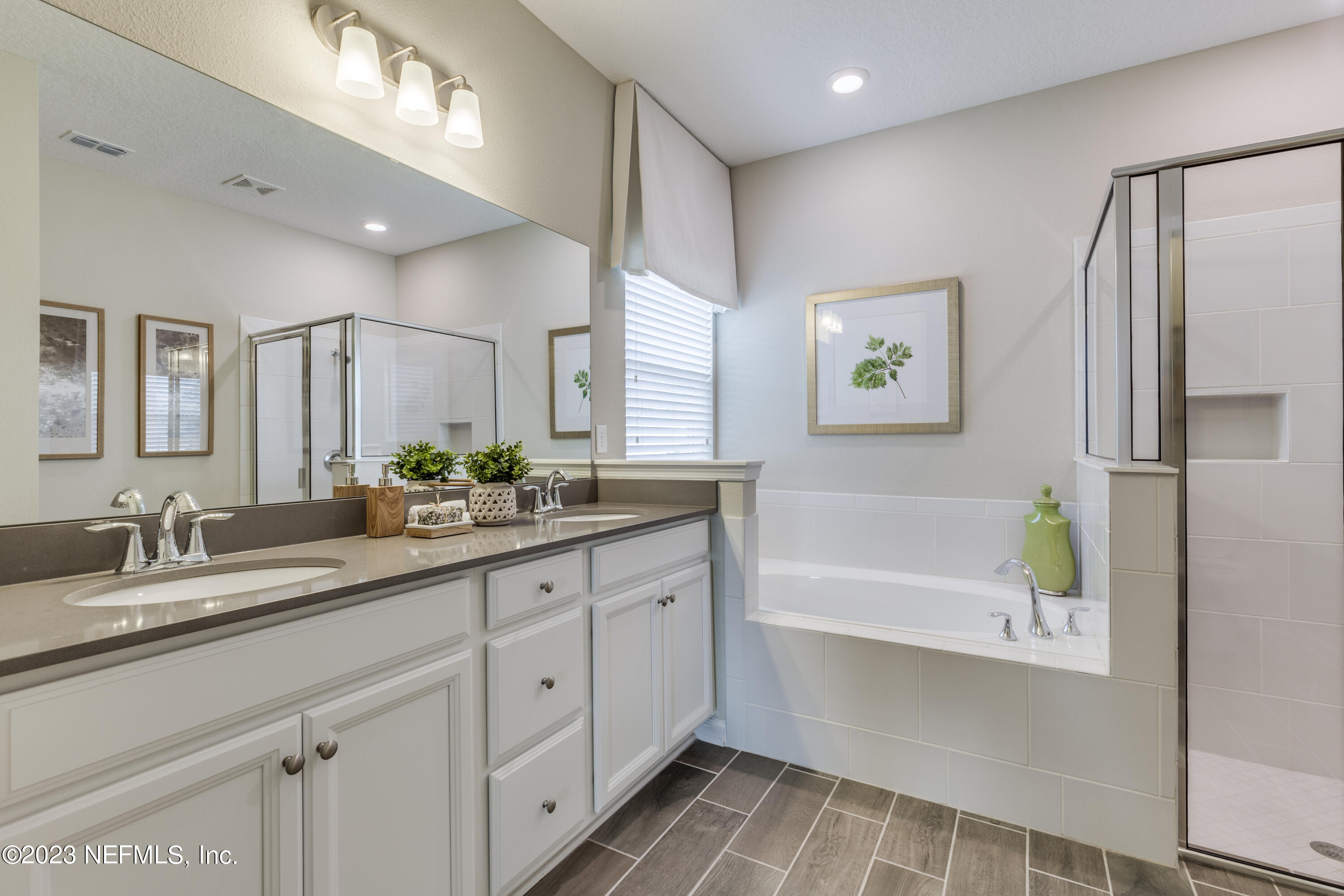 210 White Rabbit Run St. Augustine, FL 32092 - Photo 16 of 18 a bathroom with a double vanity sink a large mirror a shower and a bathtub