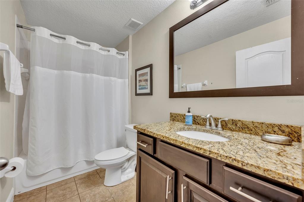 8177 Roseville Road Davenport, FL 33896 - Photo 21 of 39 a bathroom with a granite countertop sink and a mirror