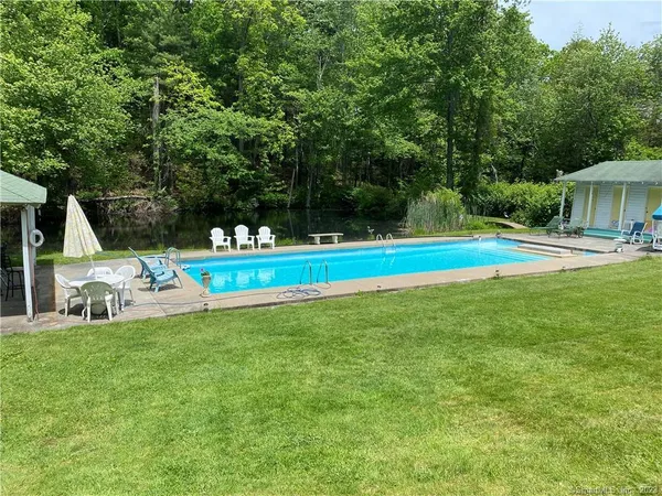 a view of a house with a backyard and swimming pool