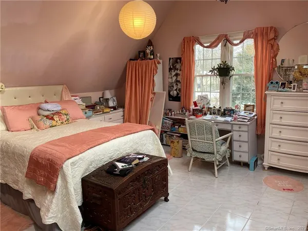 a bedroom with a bed and large windows