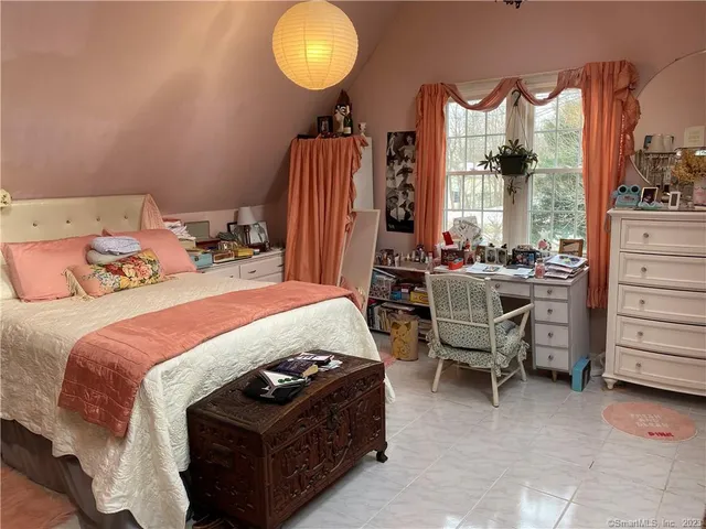 a bedroom with a bed and large windows