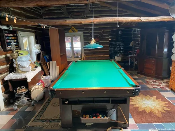 a room with pool table toys and windows