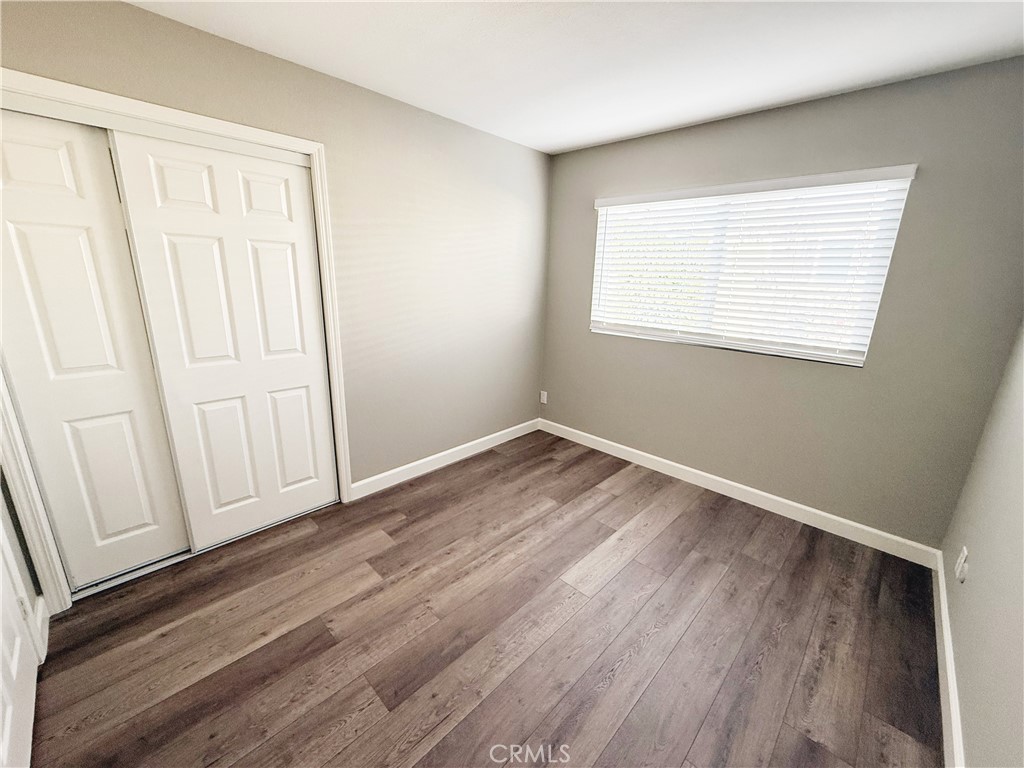 173 Oval Road, Unit 2 Irvine, CA 92604 - Photo 15 of 23 an empty room with wooden floor and windows