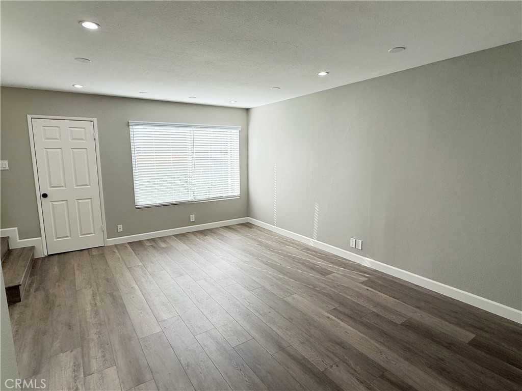 173 Oval Road, Unit 2 Irvine, CA 92604 - Photo 3 of 23 an empty room with wooden floor and window