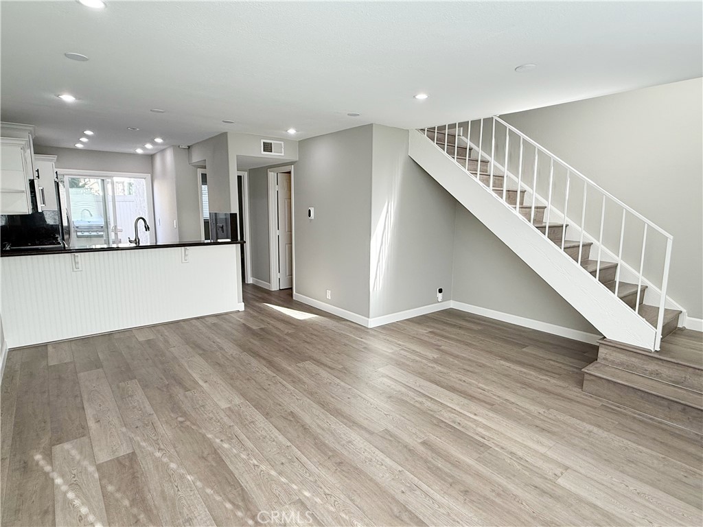 173 Oval Road, Unit 2 Irvine, CA 92604 - Photo 4 of 23 a view of a hallway with wooden floor and staircase
