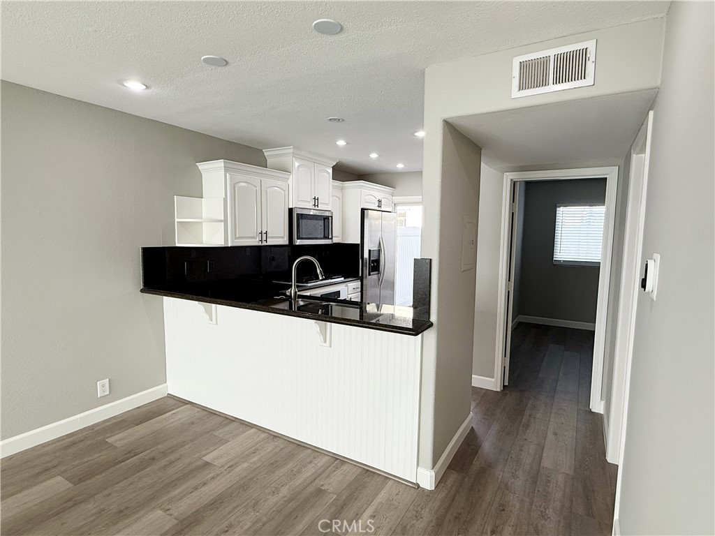 173 Oval Road, Unit 2 Irvine, CA 92604 - Photo 6 of 23 a view of a kitchen cabinets and a wooden floor