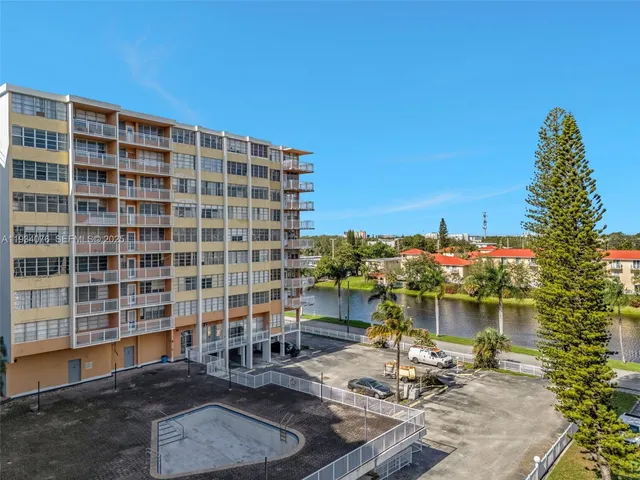 a roof deck with table and chairs and potted plants