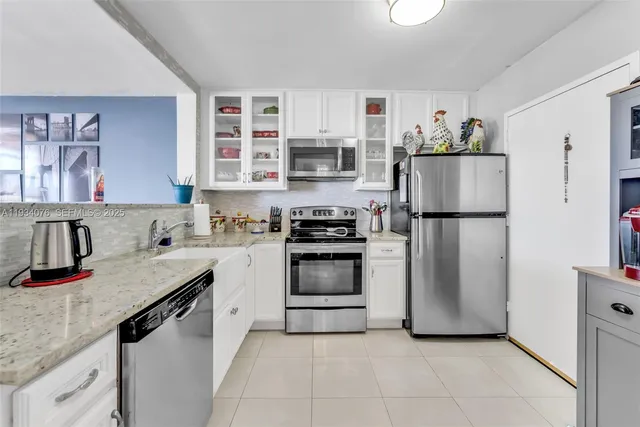 a kitchen with stainless steel appliances granite countertop a refrigerator sink and stove