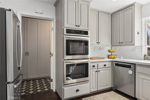 a kitchen with white cabinets and white appliances