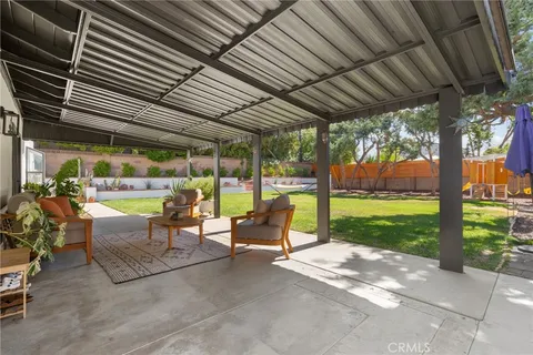 a view of a patio with table and chairs next to a yard